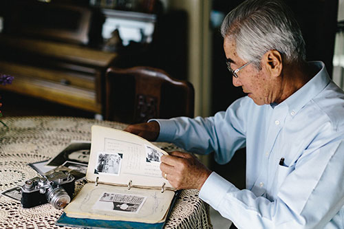 An old man looking at a photo album