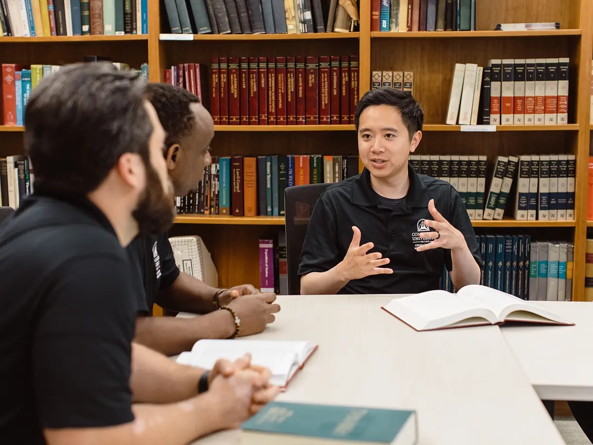 A group of people sitting at a table with books