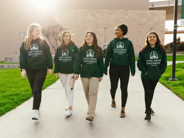 A group of women walking on a sidewalk