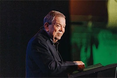 A man in a suit standing at a podium