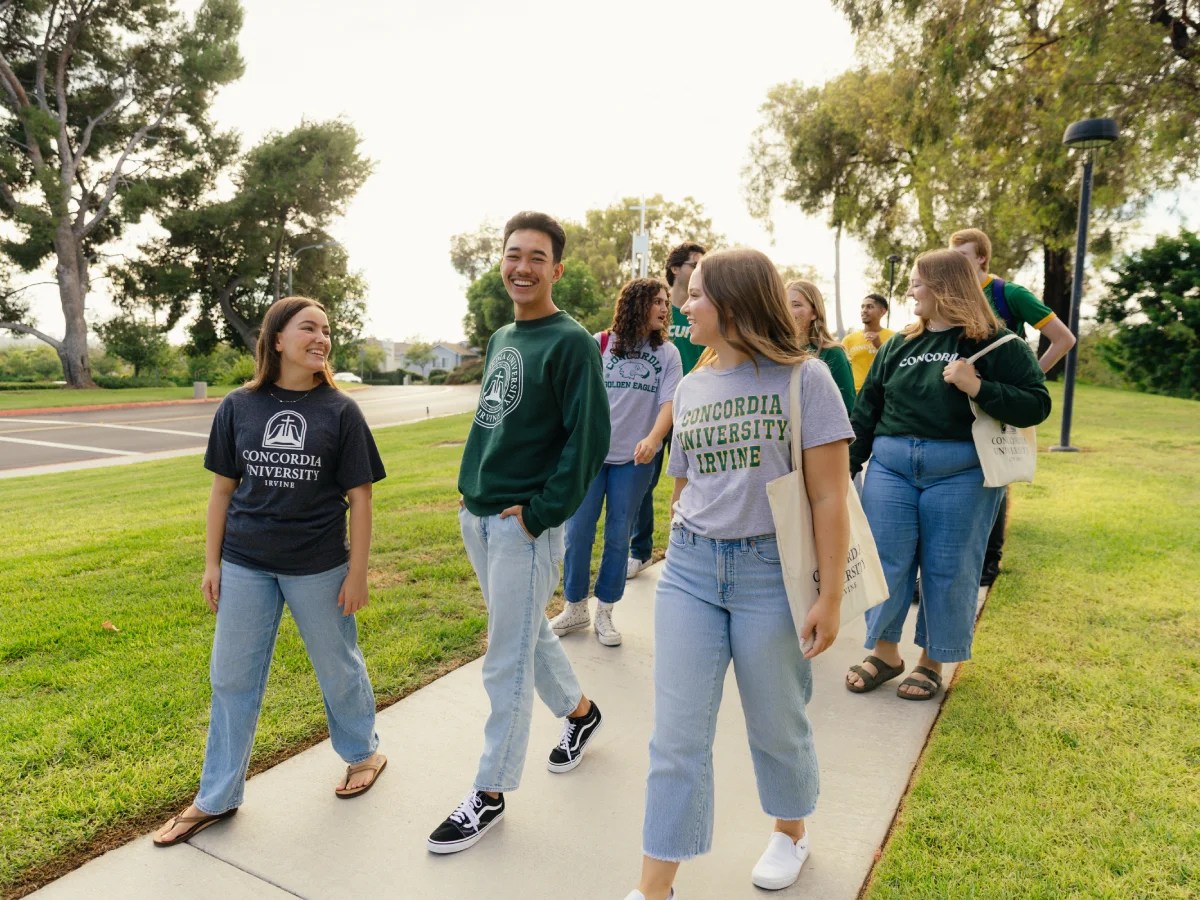 A group of people walking on a sidewalk