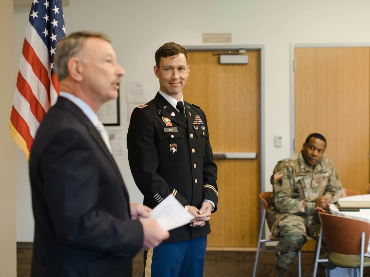 A man in a military uniform standing in front of a man in a suit