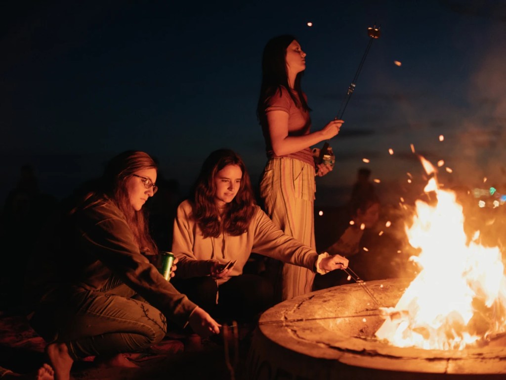 A group of women standing around a fire