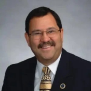 A man with a mustache wearing a suit and tie