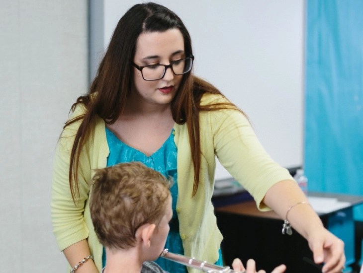 Concordia University Irvine graduate teaching a young student how to play the flute
