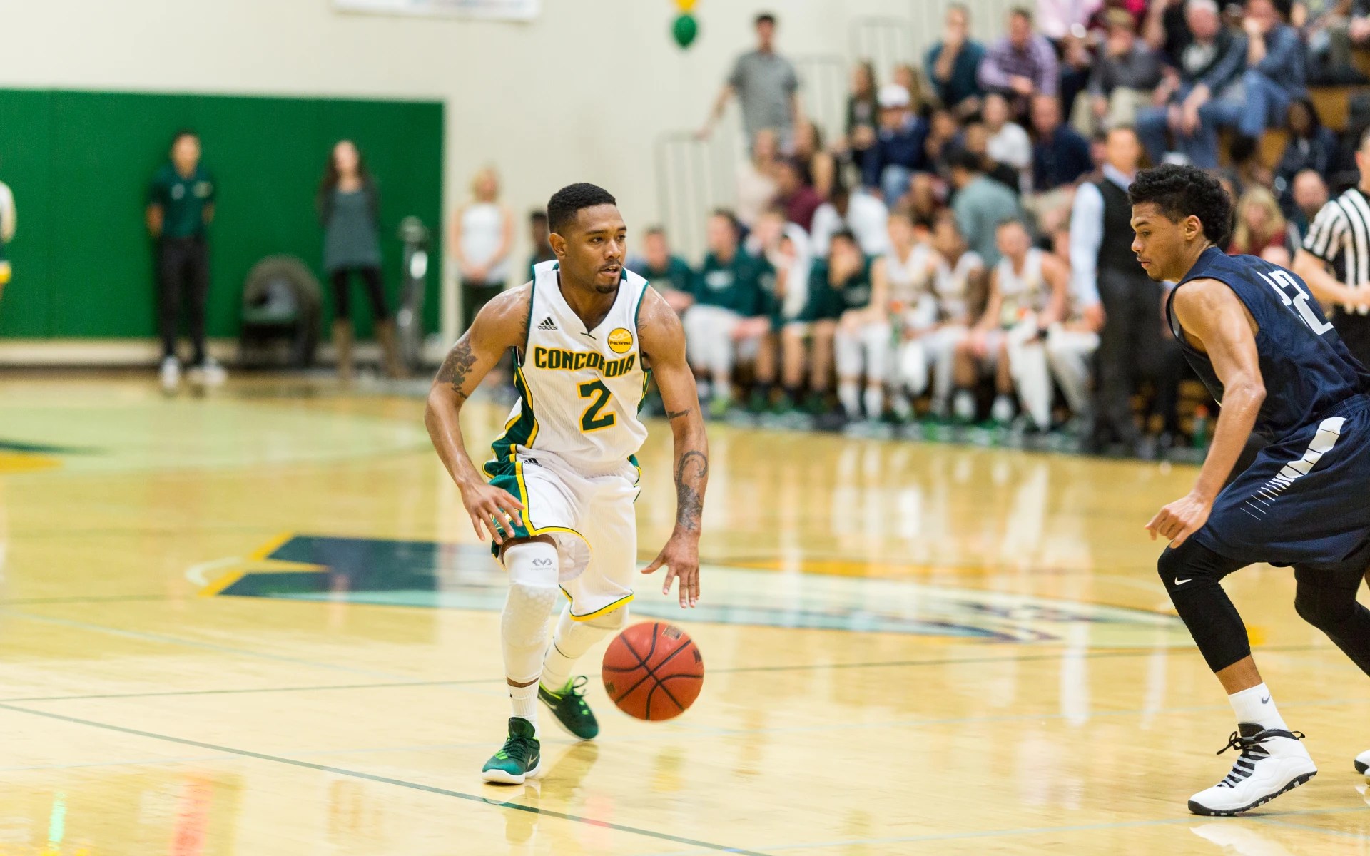 Basketball player from Concordia University Irvine dribbling the ball during a home game