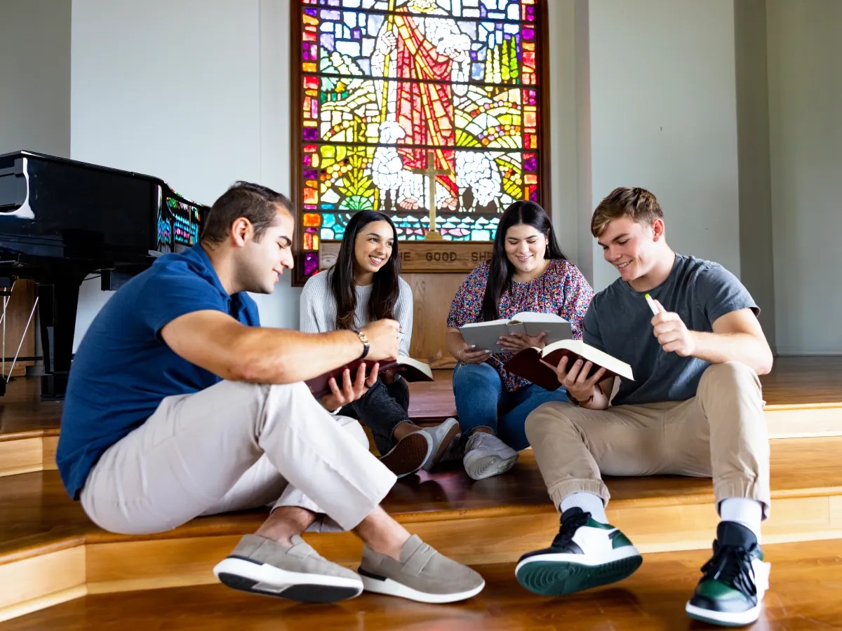A group of people sitting on the floor reading books