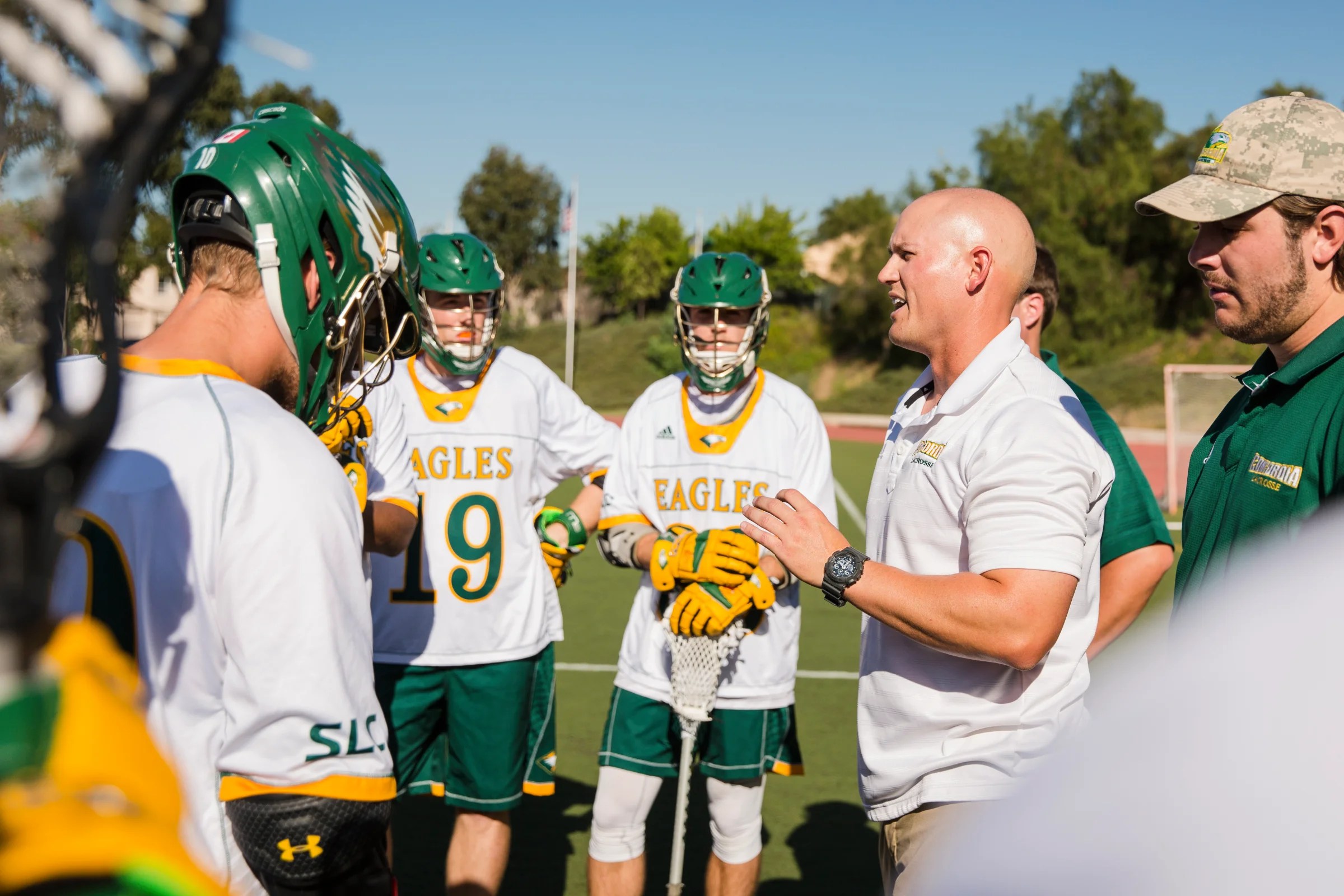 Concordia University Irvine coach giving instructions to players during a team huddle