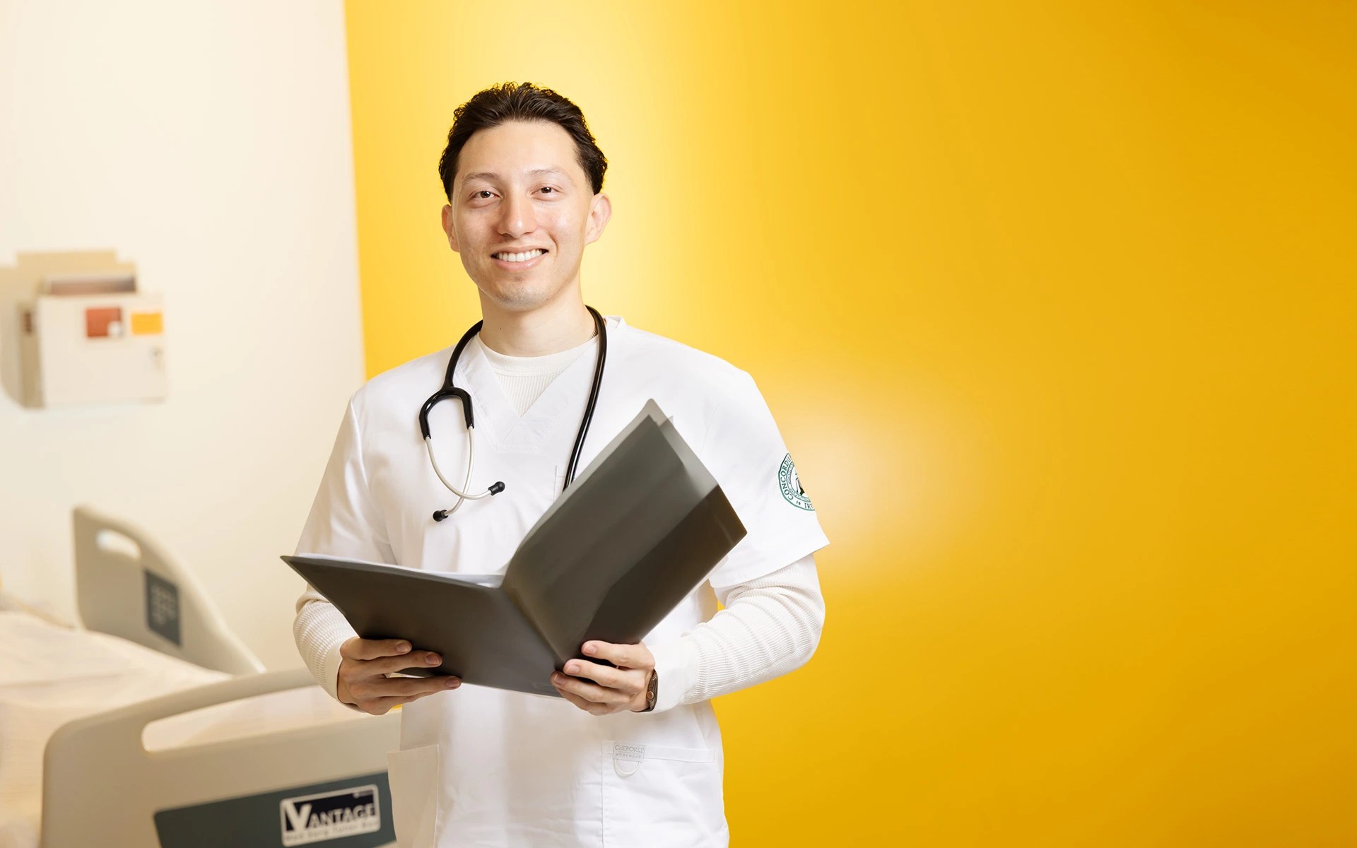 A man in a white coat holding a file