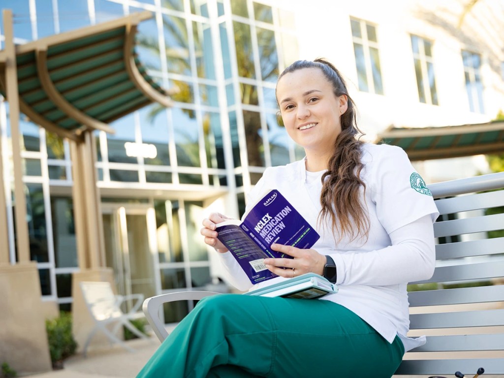 A woman sitting on a bench reading a book