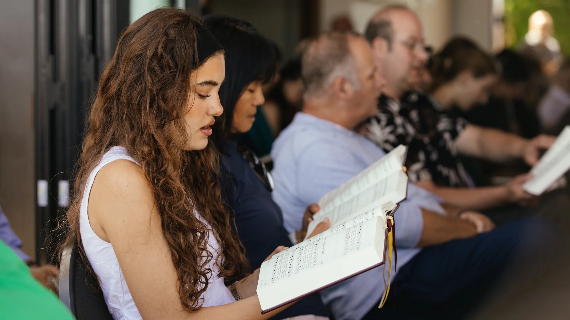 Concordia University Irvine students and faculty singing hymns during a chapel service while holding hymn books