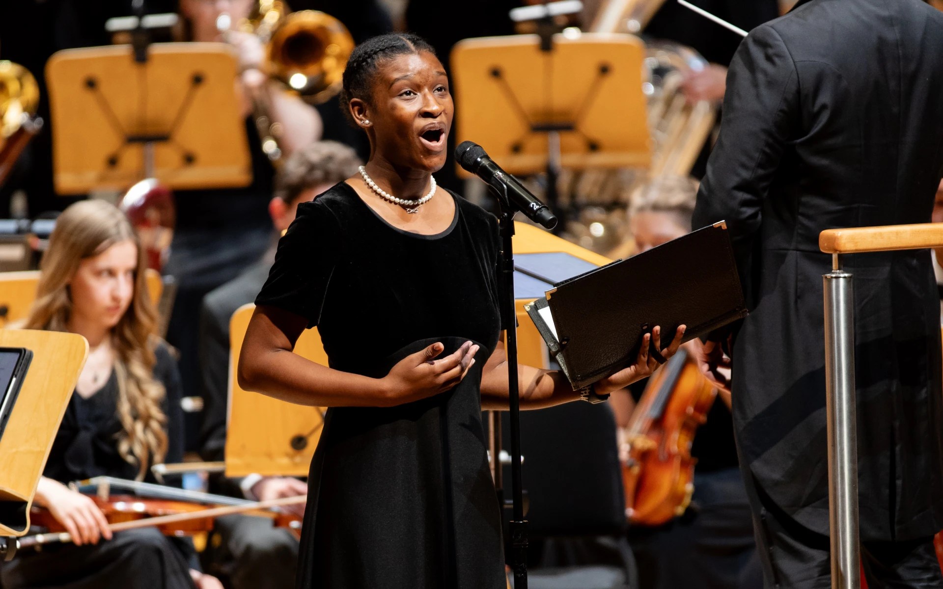 A Concordia University Irvine student performs a vocal solo during a Christmas concert with choir and orchestra