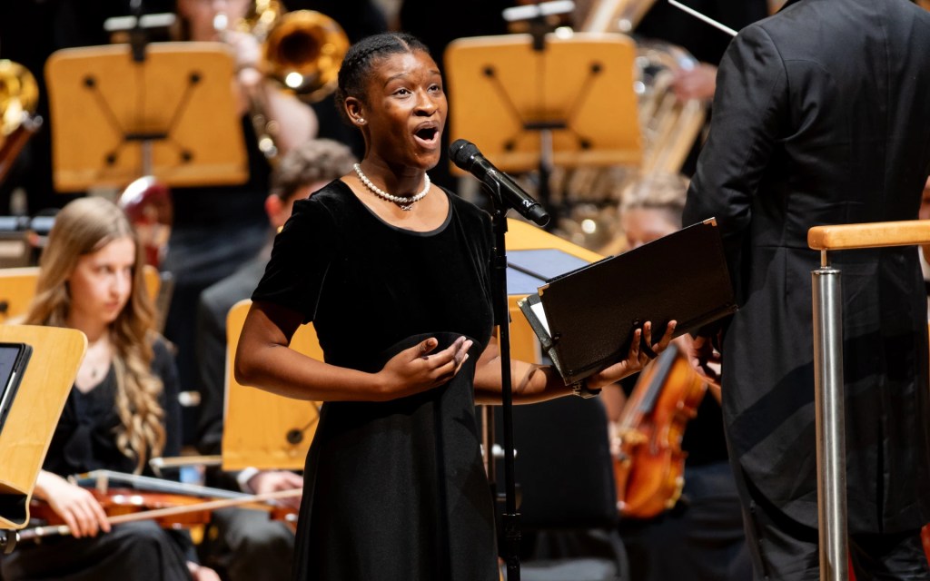 A Concordia University Irvine student performs a vocal solo during a Christmas concert with choir and orchestra