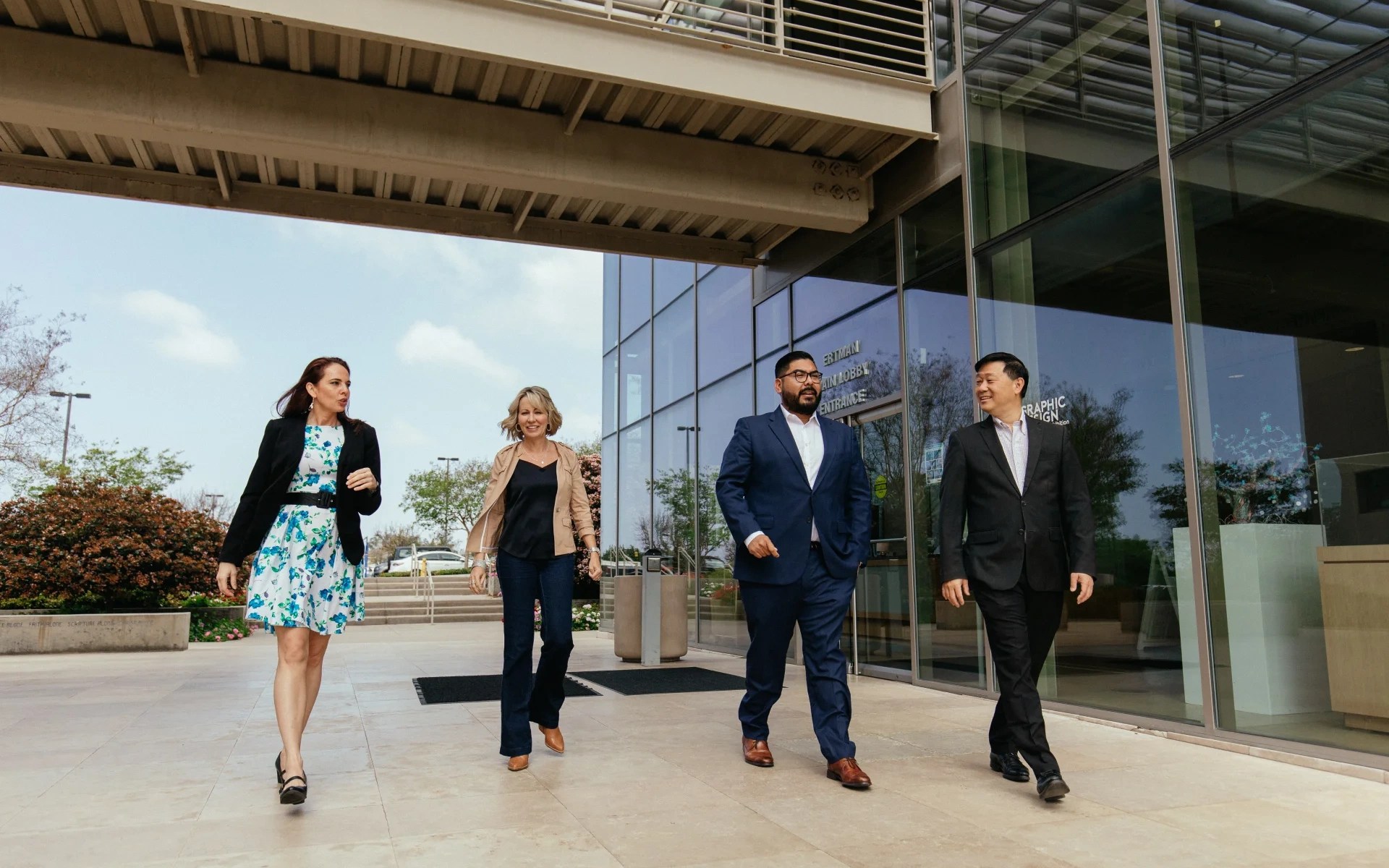 Group of faculty and staff walking together outside a campus building