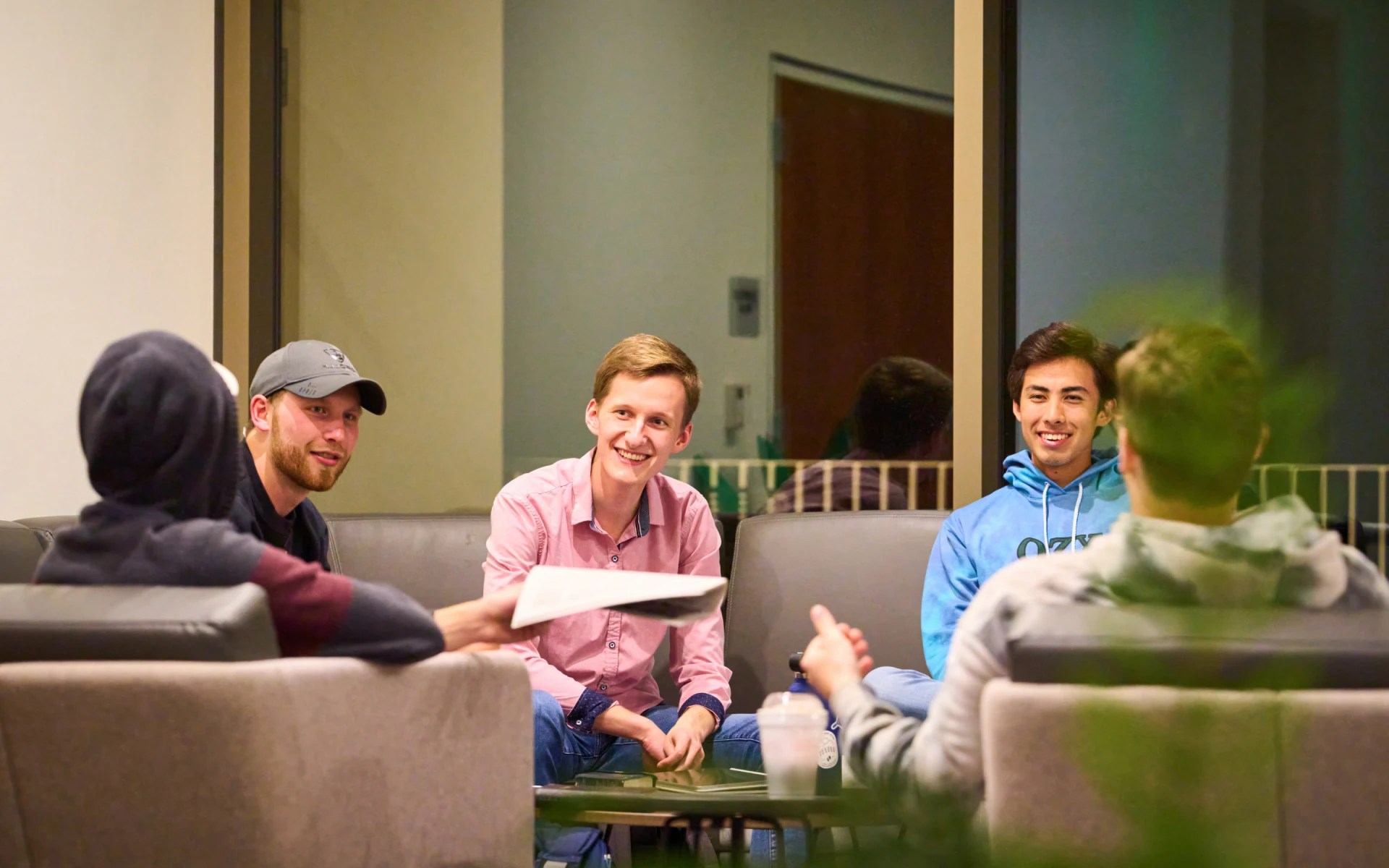 Group of students having a discussion and smiling in a lounge area at Concordia University Irvine