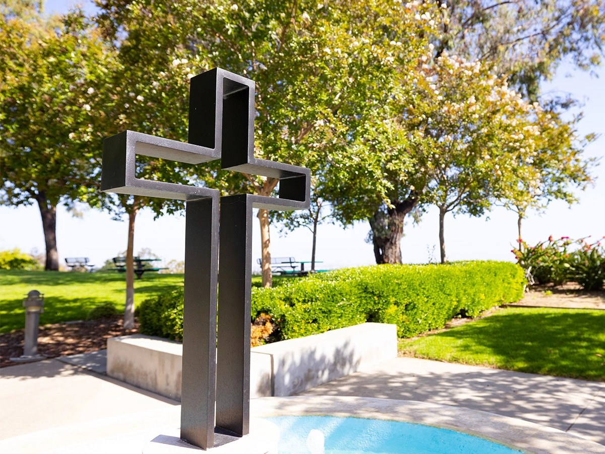 A cross statue in a park