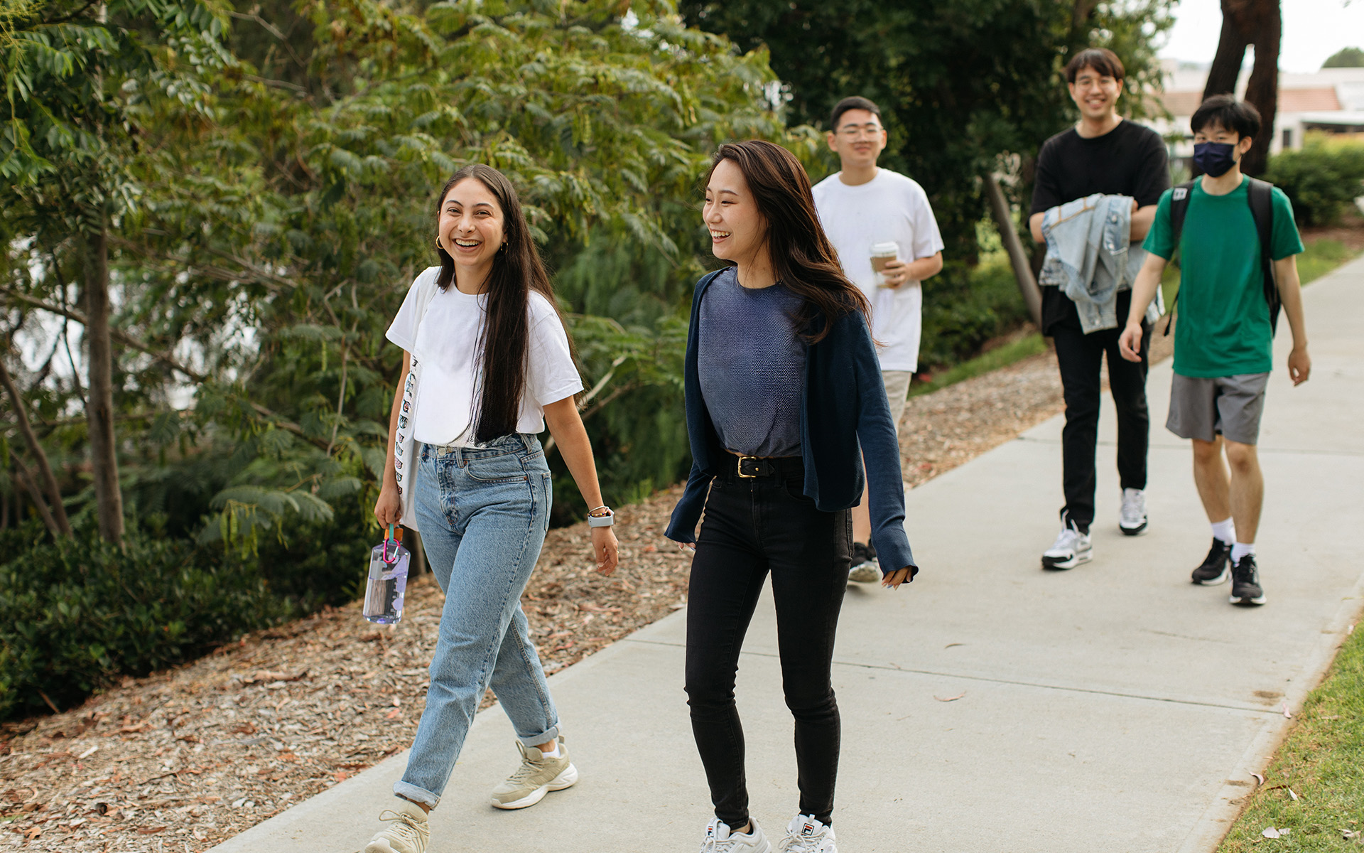 A group of people walking on a sidewalk