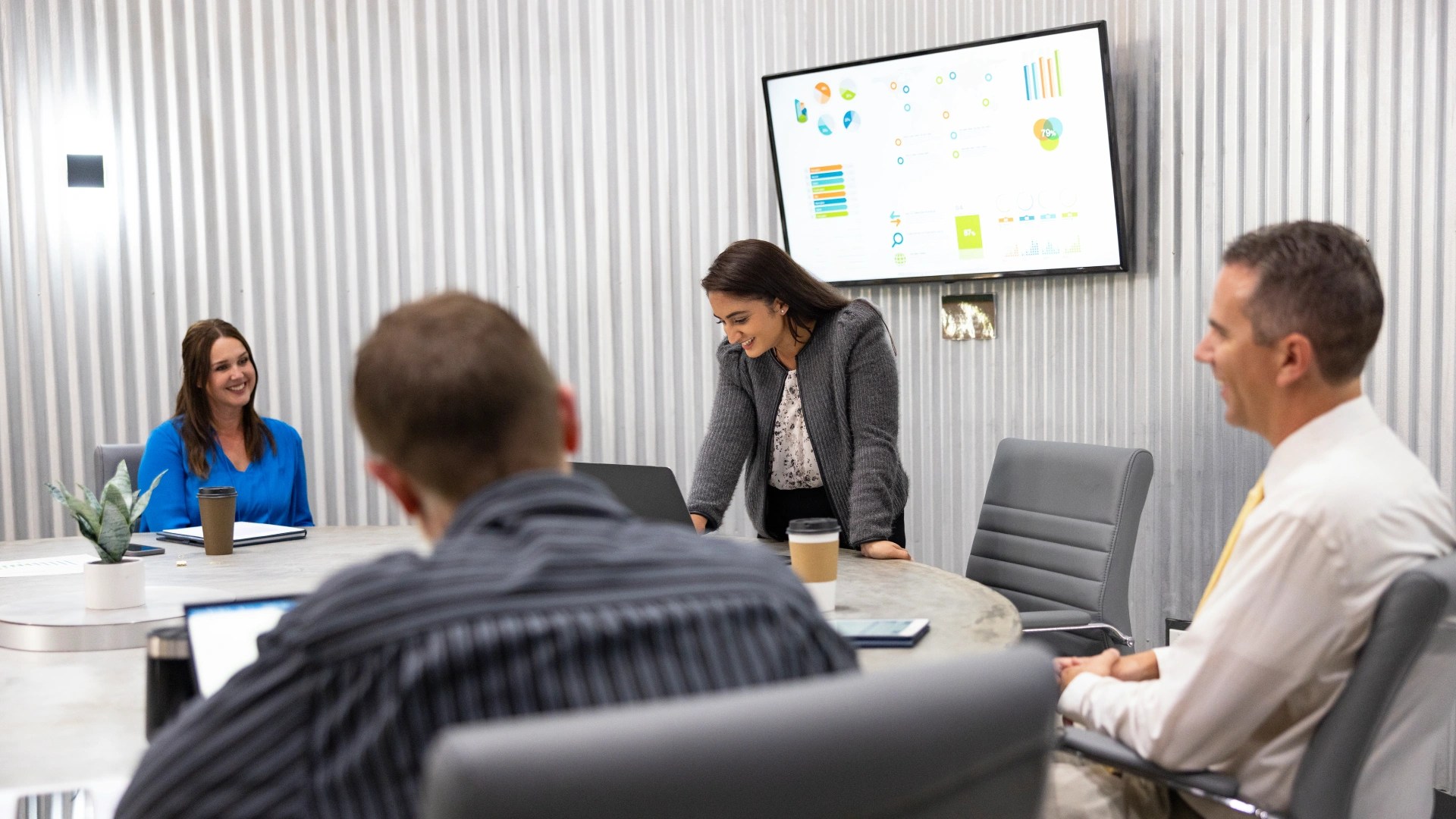 A woman standing at a table with a laptop