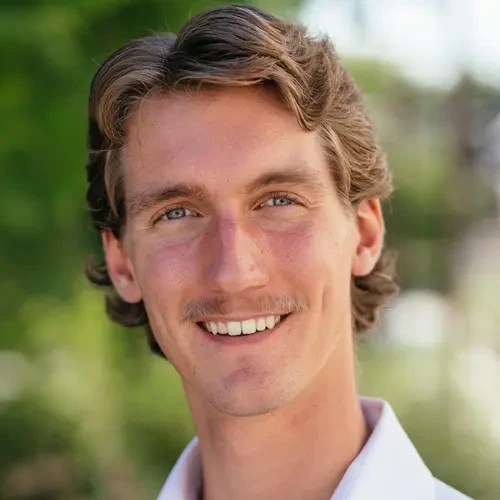 A man with a mustache smiling
