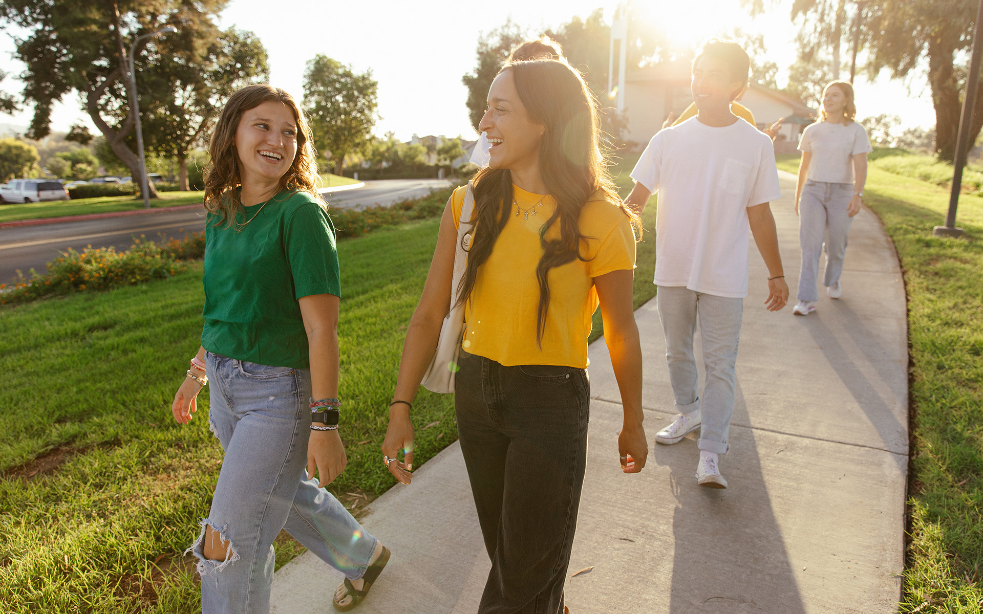 A group of people walking on a sidewalk