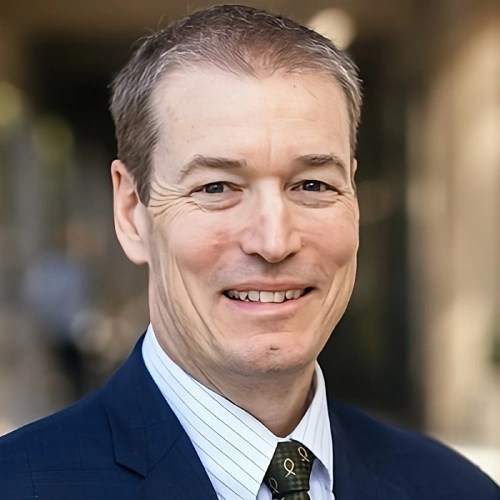 A man in a suit smiling