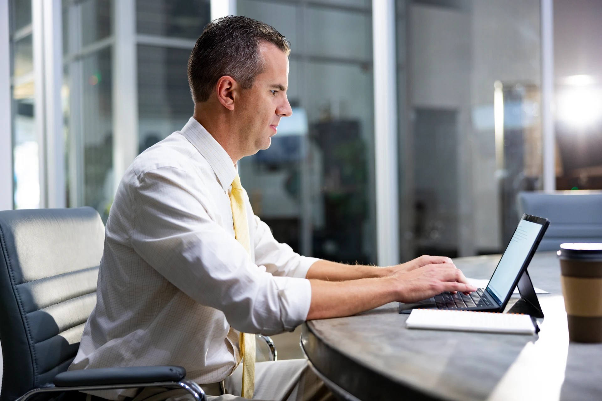 Man typing on laptop in an office