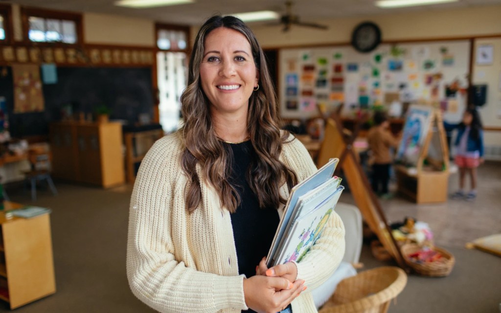 Concordia University Irvine graduate holding books in an early childhood classroom