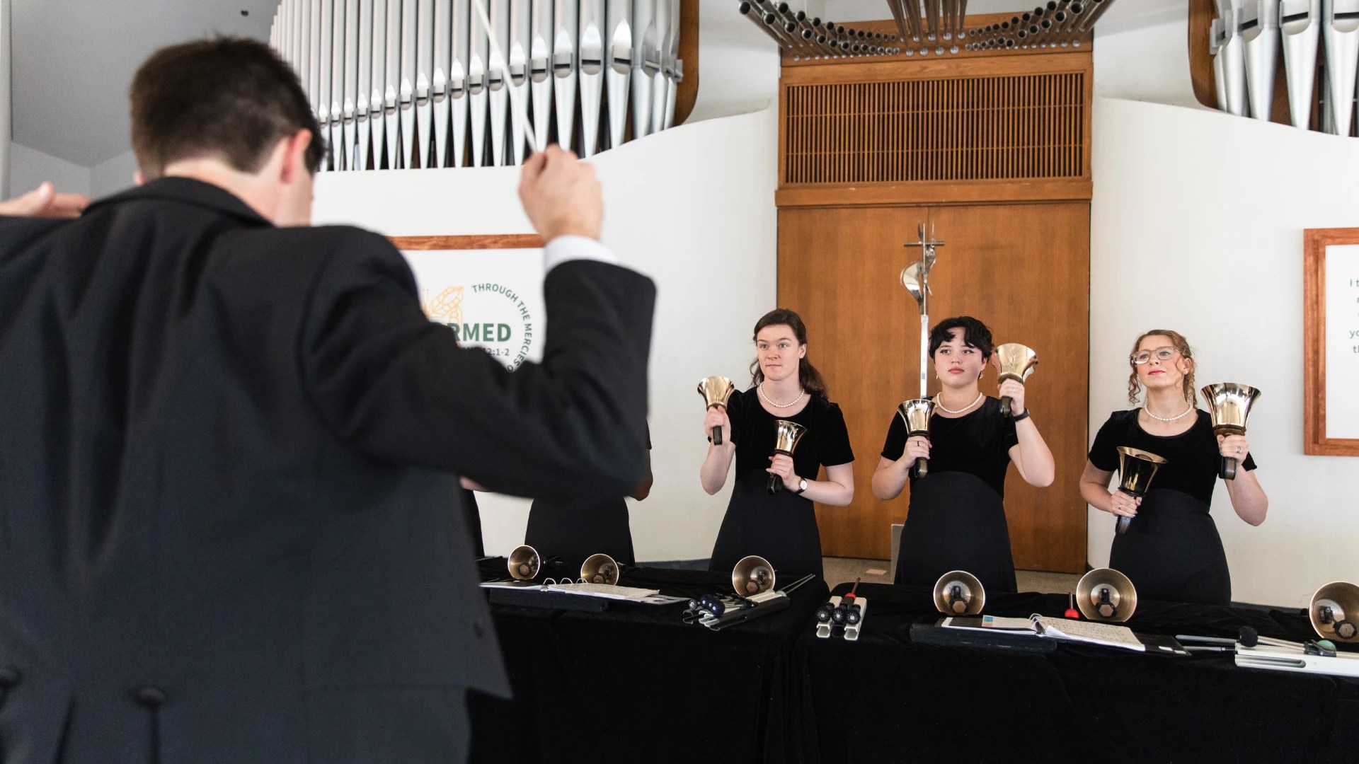A group of people holding bells