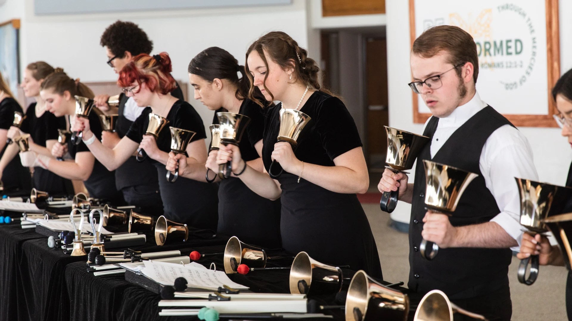 A group of people holding bells