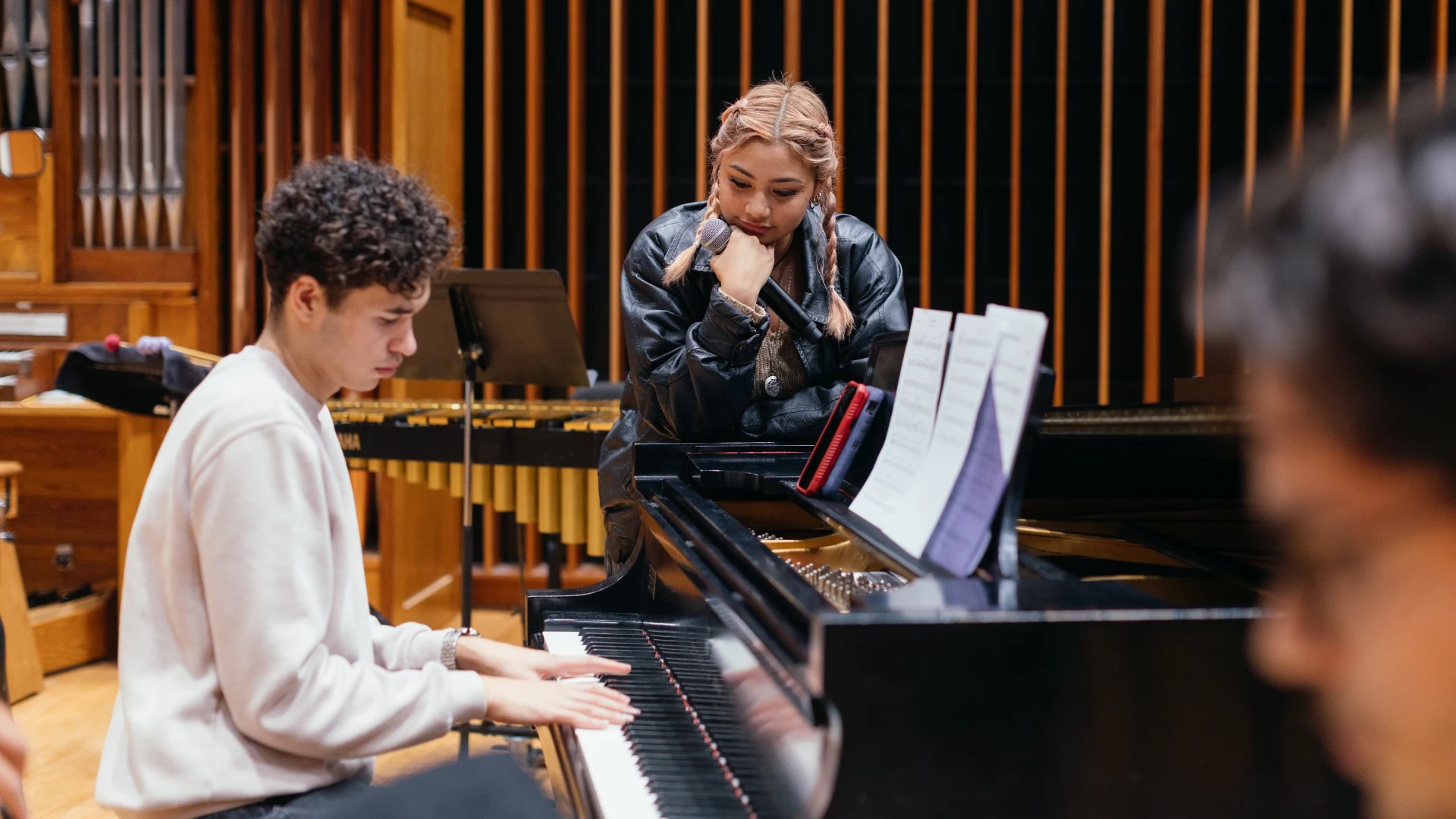 A woman sitting at a piano with a microphone