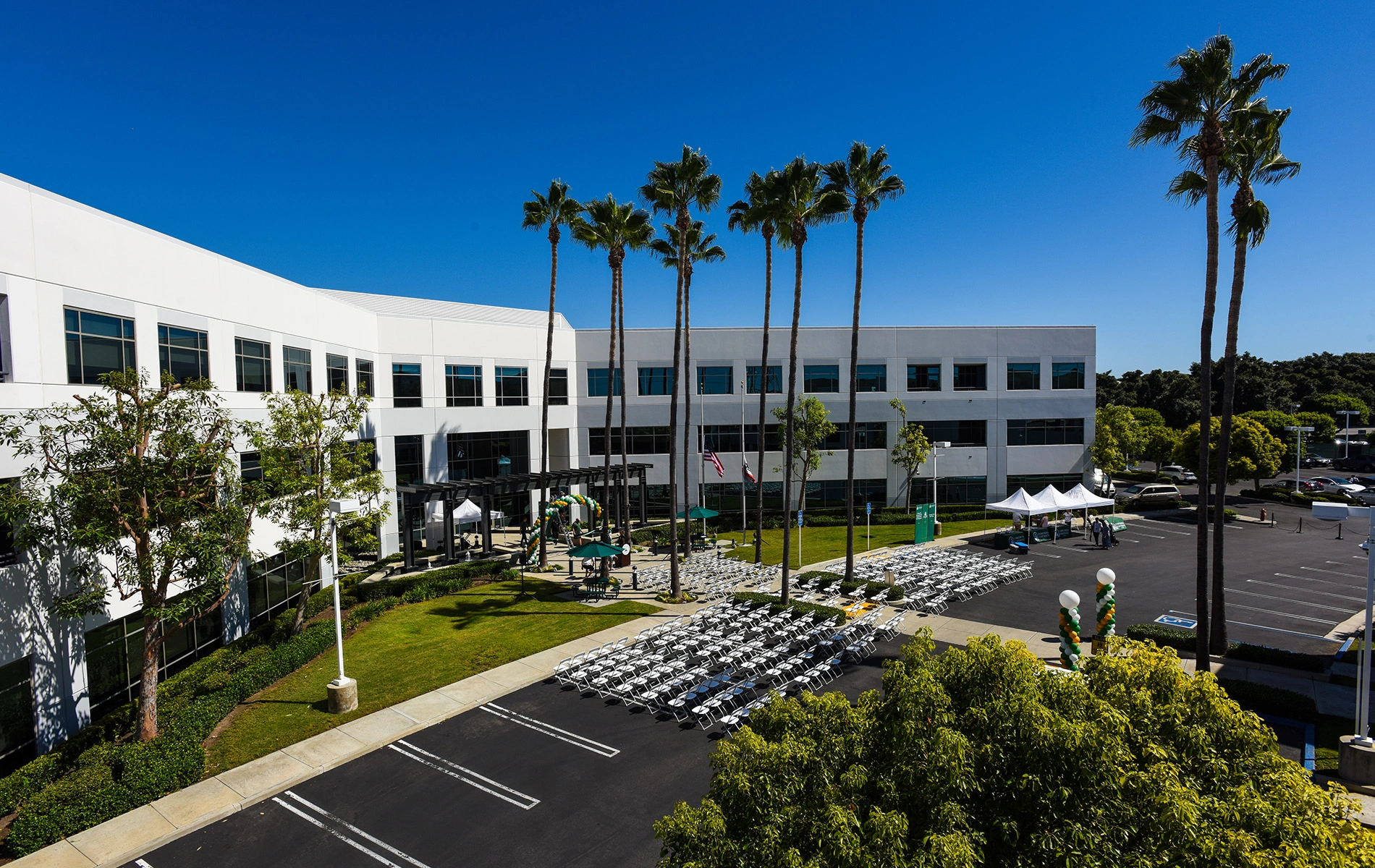 A building with palm trees and a parking lot