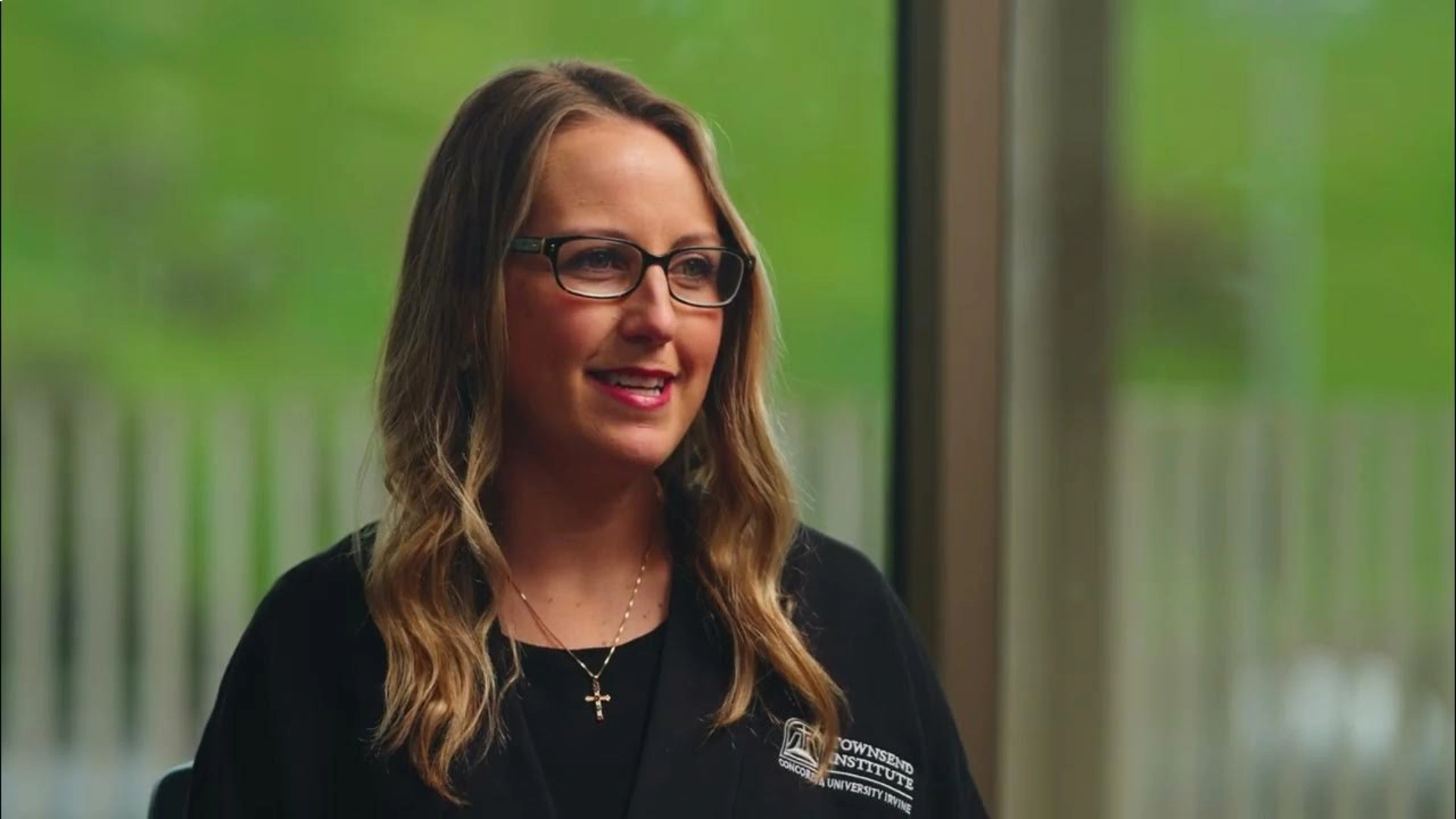 A woman wearing glasses and a black shirt