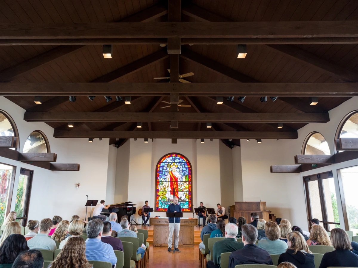 A man standing in front of a group of people in a church