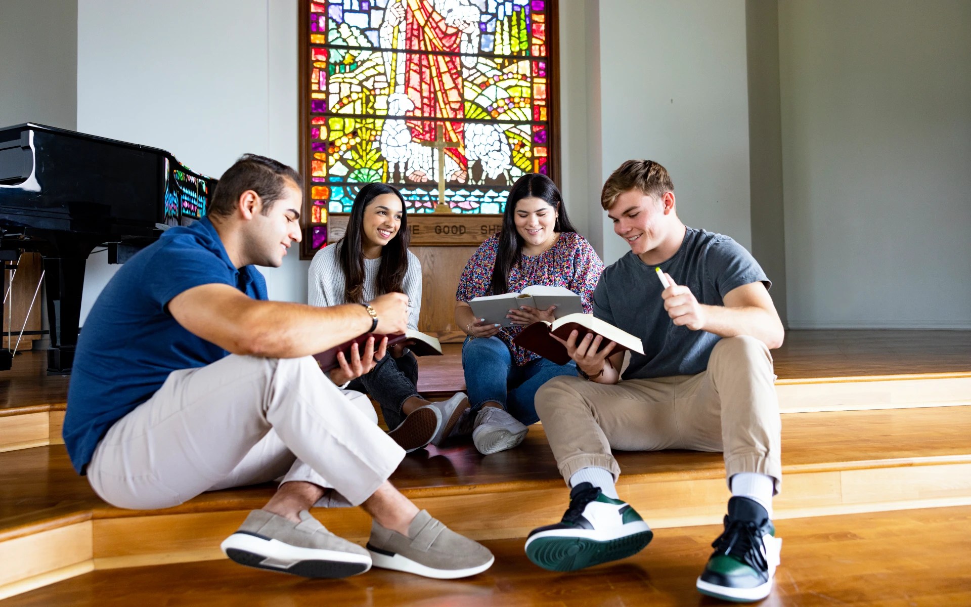 A group of people sitting on stairs reading books