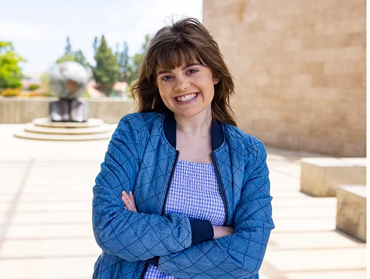 A woman smiling with arms crossed