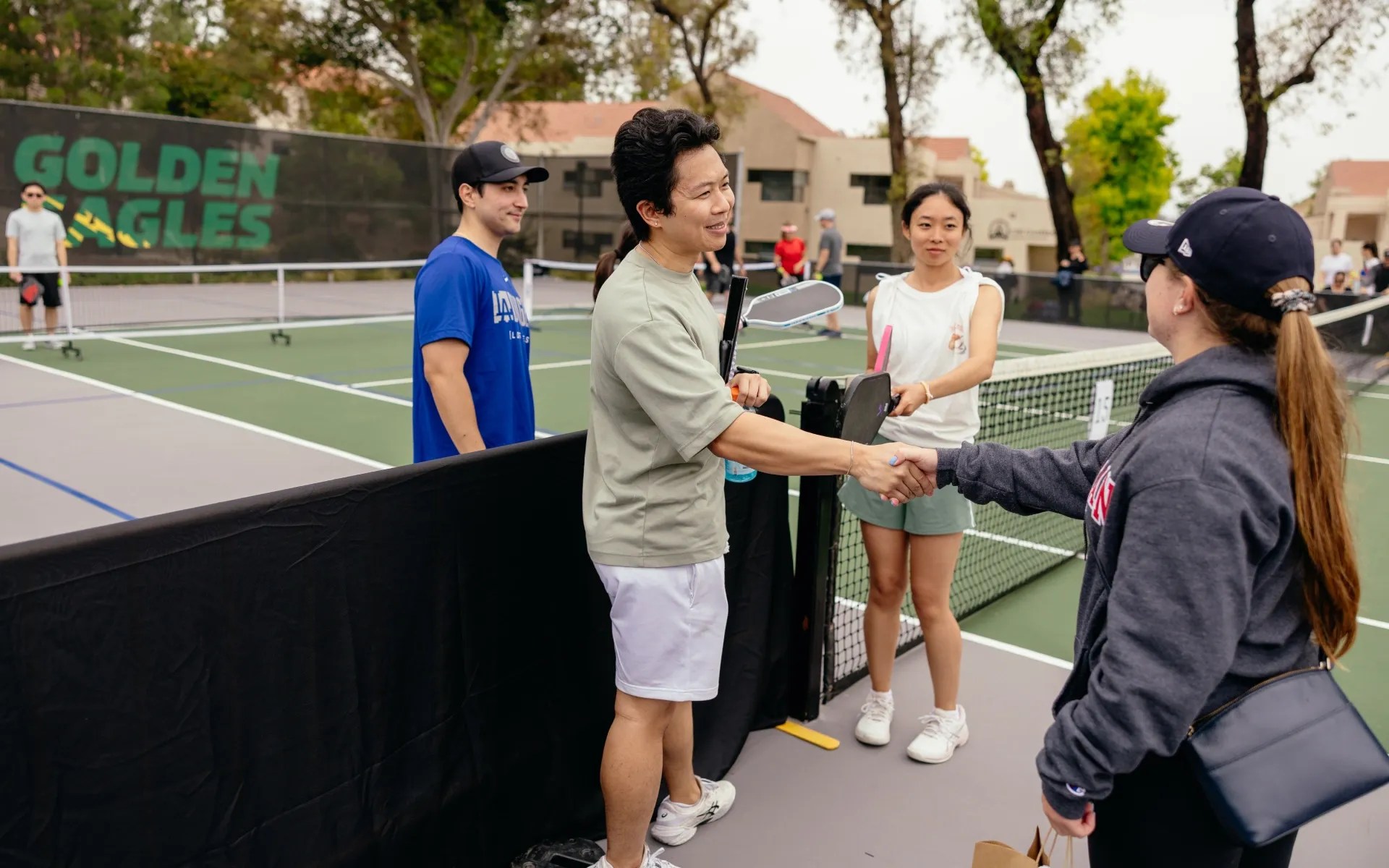 A man shaking hands with a tennis player