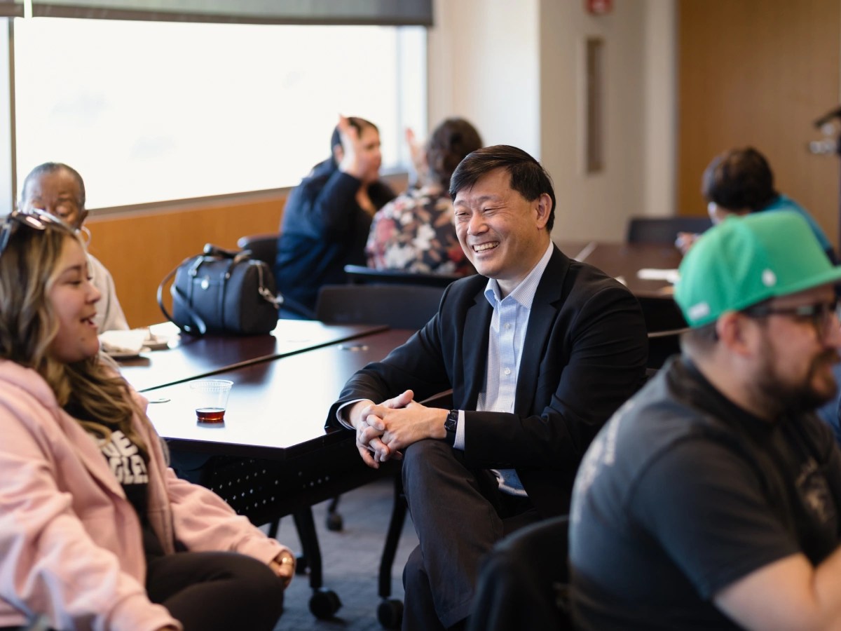 A man sitting in a room with people in the background