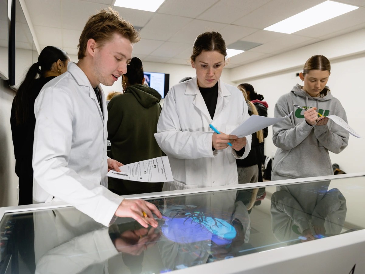 A group of people in lab coats looking at a display