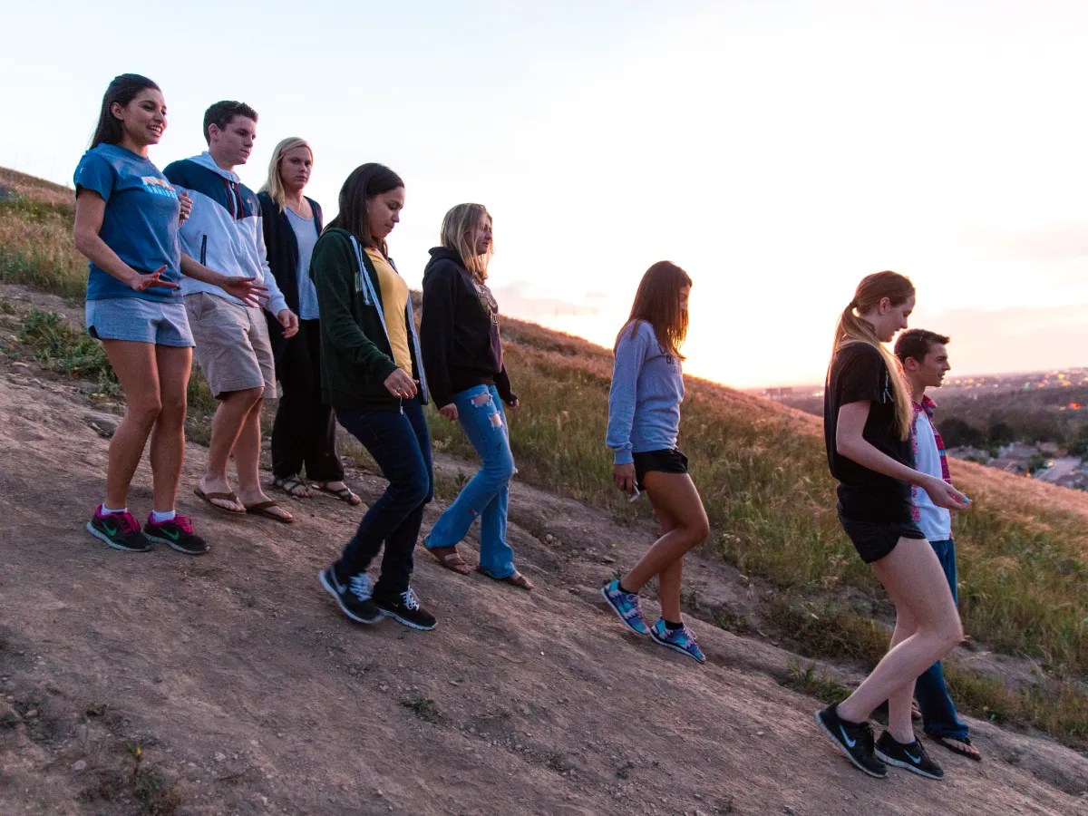 A group of people walking up a hill