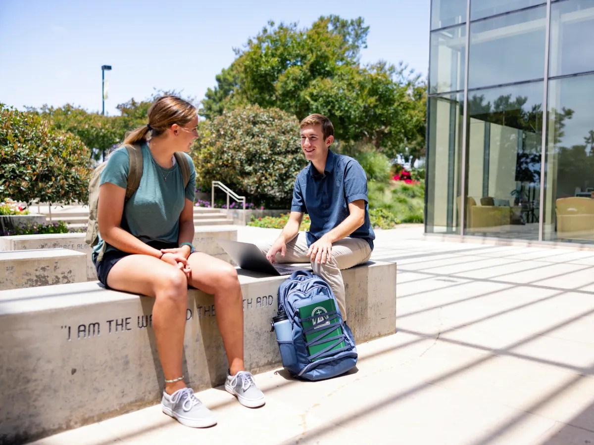 A man and woman sitting on a concrete bench