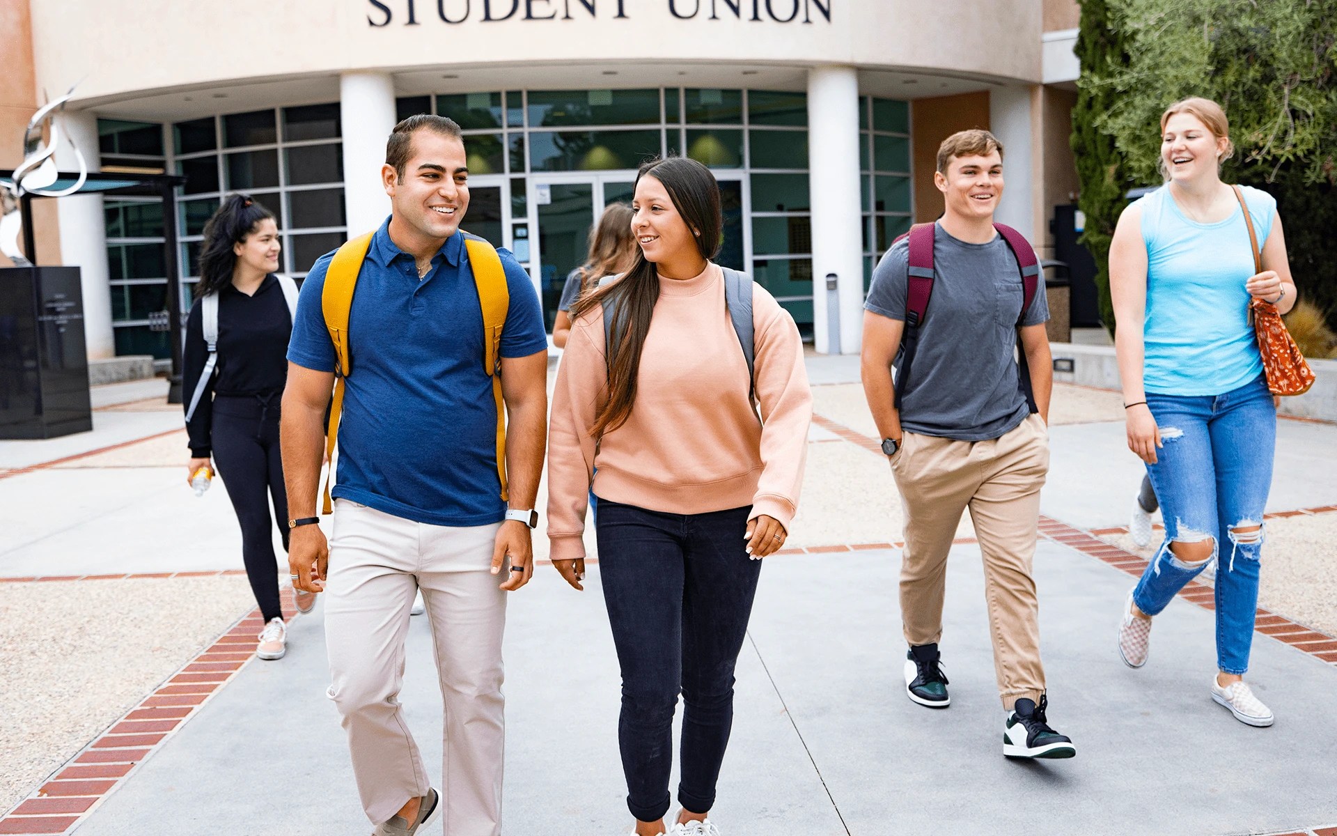A group of people walking outside of a building