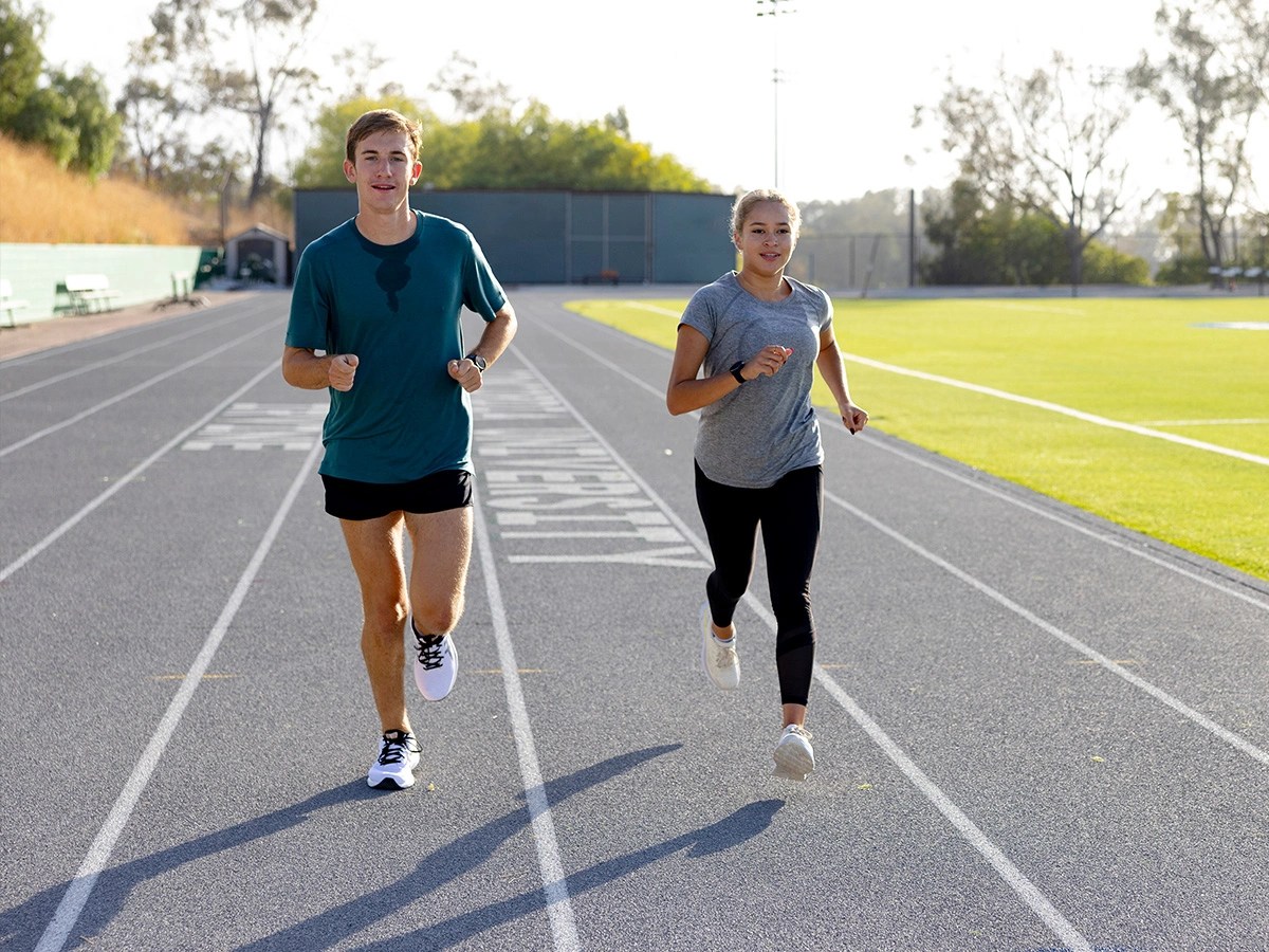 A man and woman running on a track