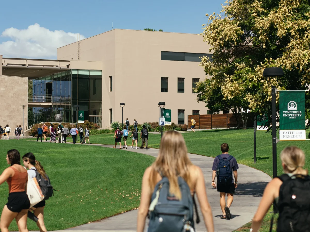 A group of people walking on a path in front of a building