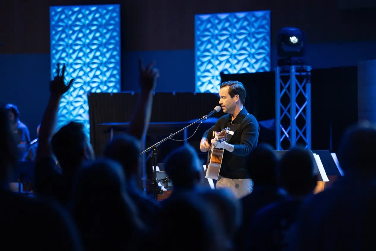 A man playing a guitar in front of a crowd