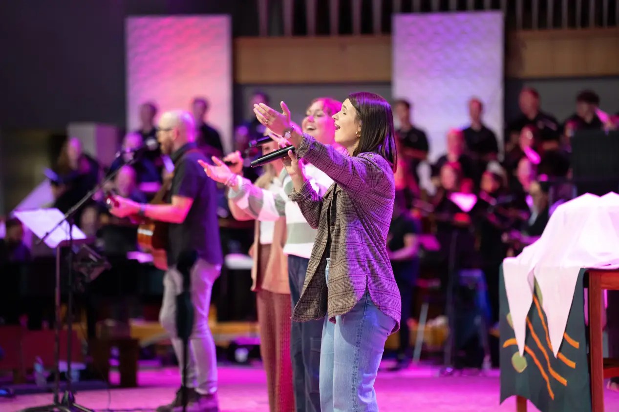 A group of people singing on a stage