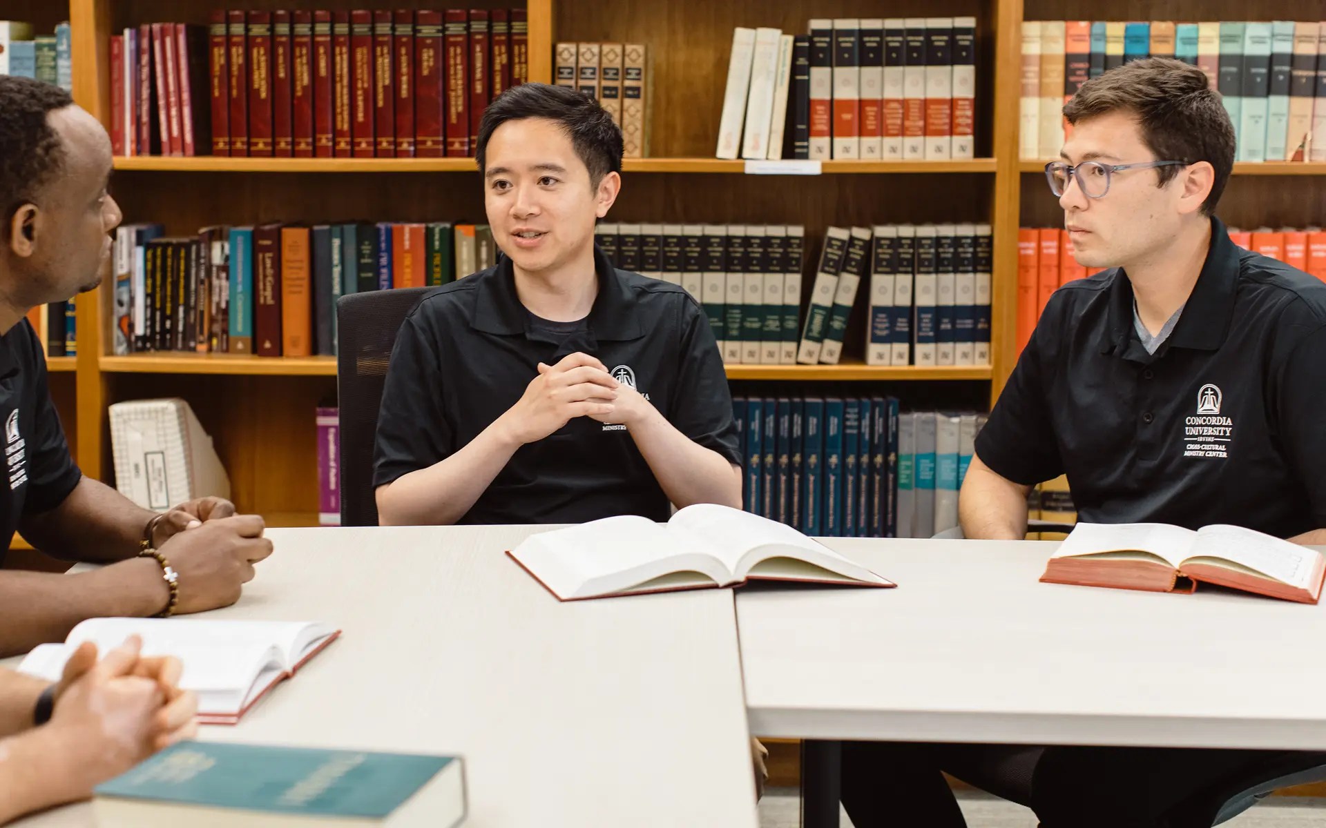 A group of people sitting at a table with books