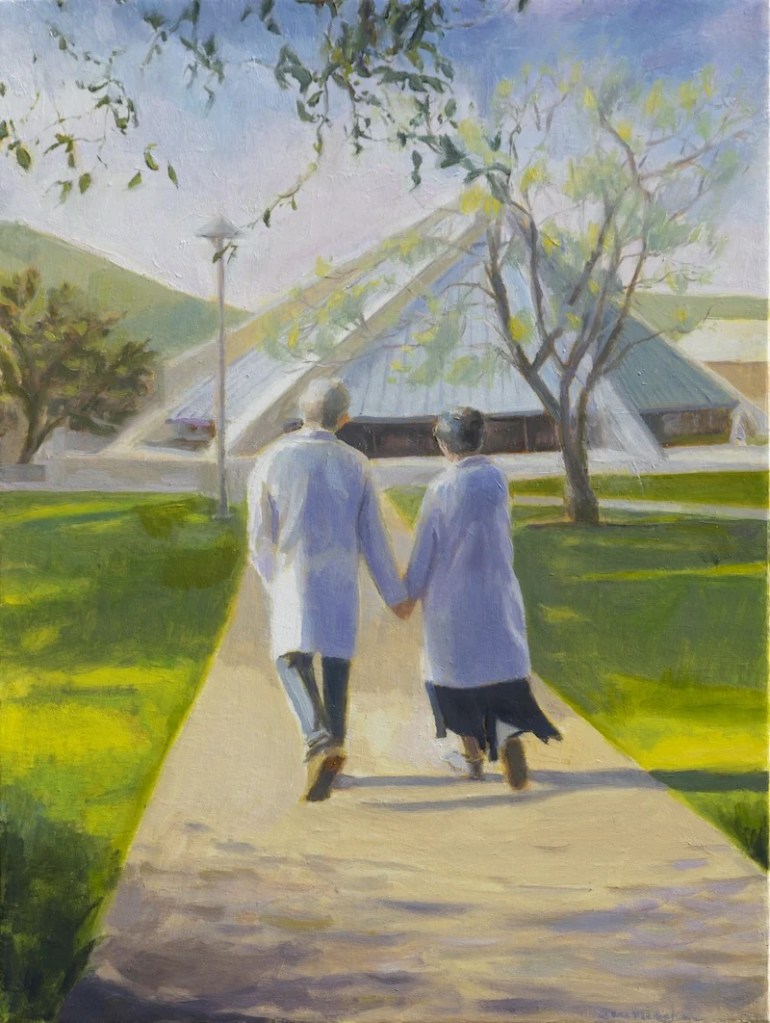 A man and woman holding hands walking on a sidewalk