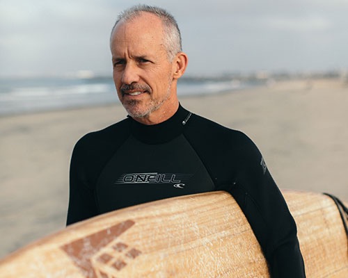 A man holding a surfboard on a beach