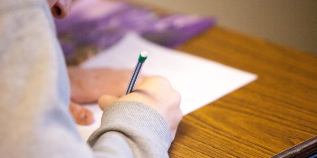 A person writing on a piece of paper