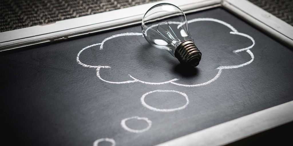 A light bulb on a chalkboard